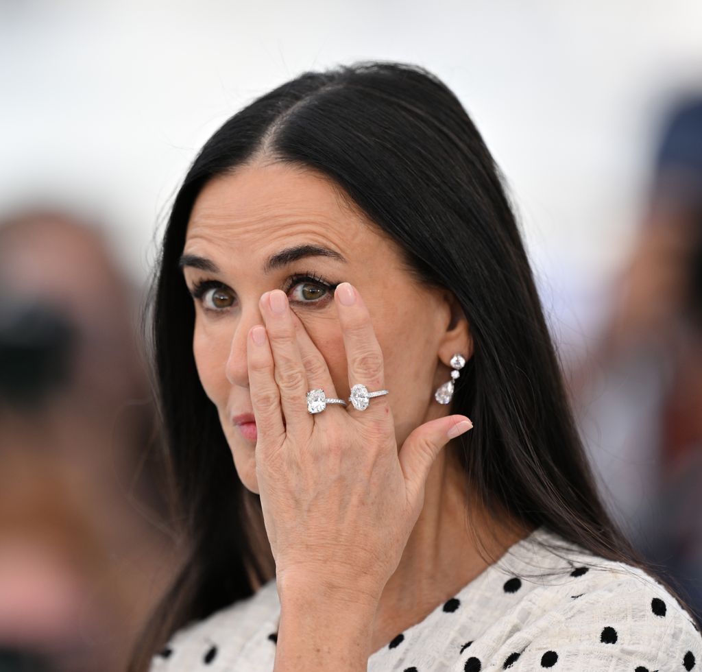 Demi Moore puts her hand on her face