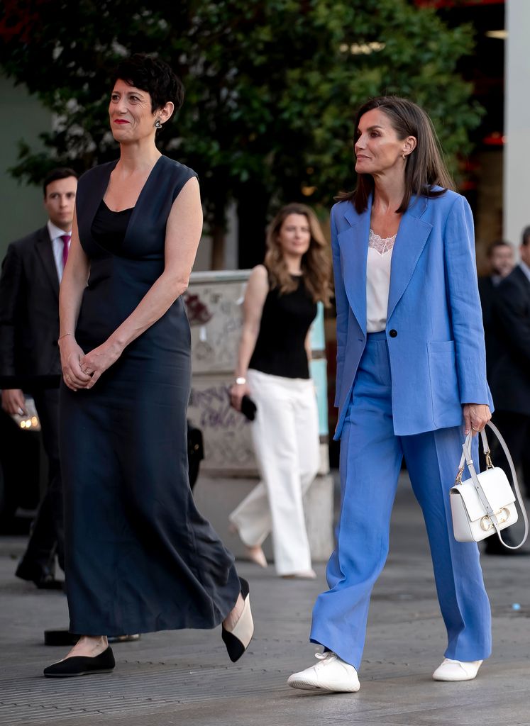 Queen Letizia of Spain in a blue suit and Elma Saez Delgado walking