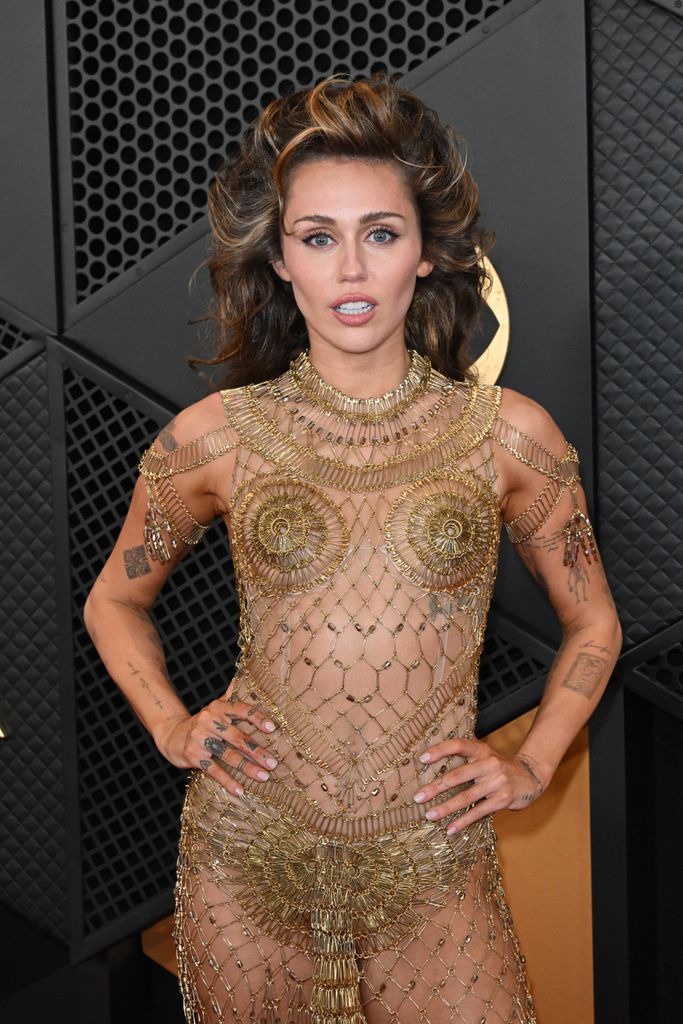 Miley Cyrus shows off her tattoos in gold mesh dress at Grammy Awards 