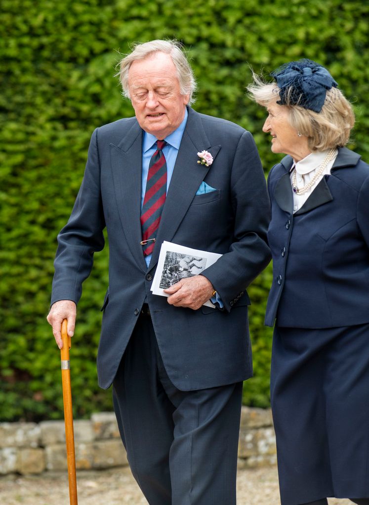 Andrew Parker Bowles walking with a woman and a stick