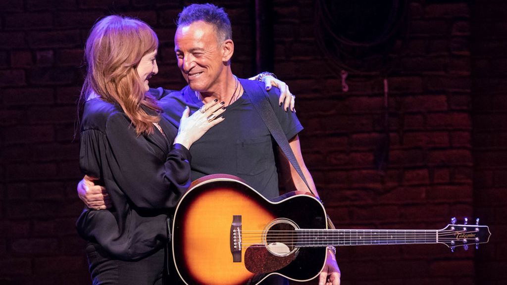 Bruce Springsteen and his wife Patti Scialfa embrace each other on stage. 