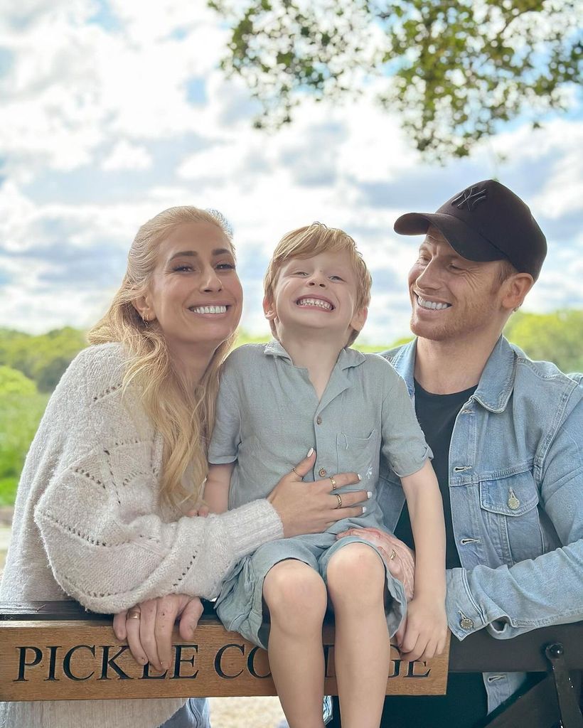 Stacey Solomon and her husband Joe Swash sitting on a fence with their son Rex