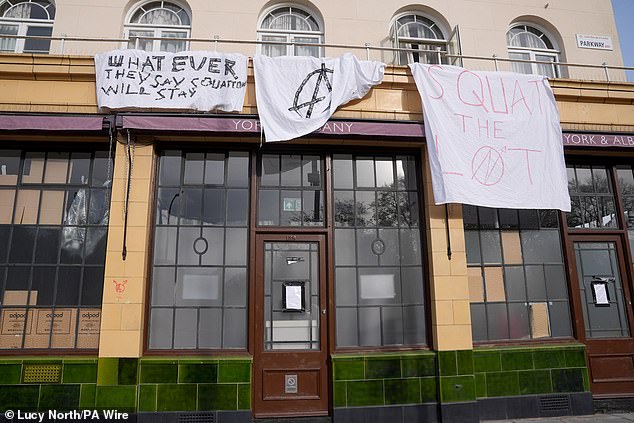 The Grade II listed pub is covered in sheets and handmade banners bearing the group's messages