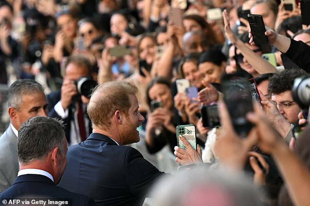 Fans took photos as Prince Harry shook hands outside St Paul's Cathedral yesterday