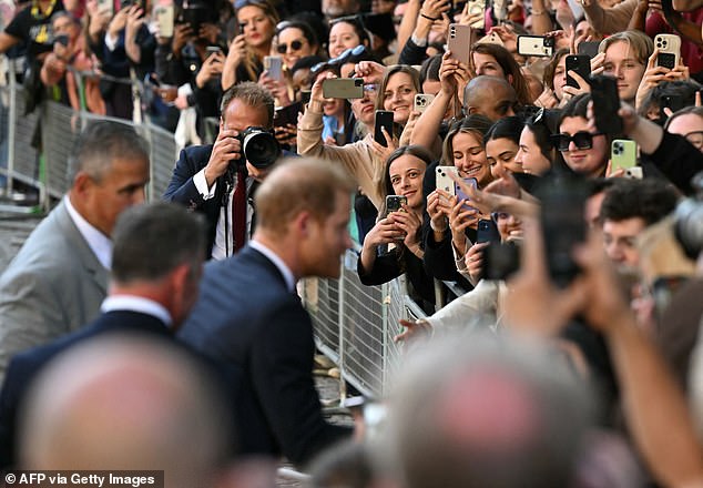 Fans took photos of Prince Harry as he greeted well-wishers in St Paul's yesterday
