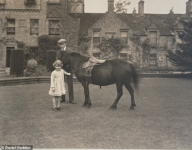 Young Elizabeth playing with a pony in the grounds of Glamis Castle, wearing a floral dress, now at auction