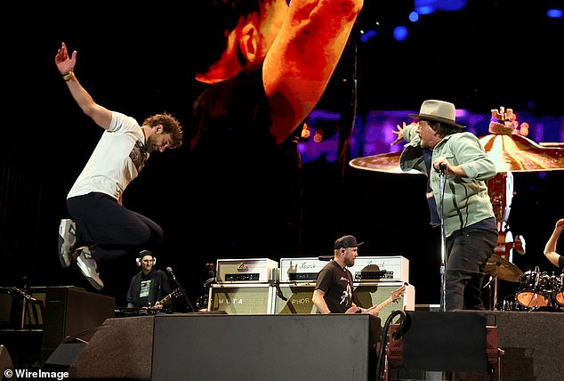 Mimicking the image on his T-shirt, Cooper showed off his rocker-inspired high jump while performing singer-songwriter Neil Young's Rockin' in the Free World with Vedder and the band.