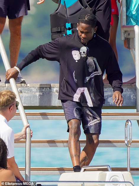 For their yacht day, Travis looked effortlessly stylish in a graphic quarter-zip sweatshirt and swimming trunks