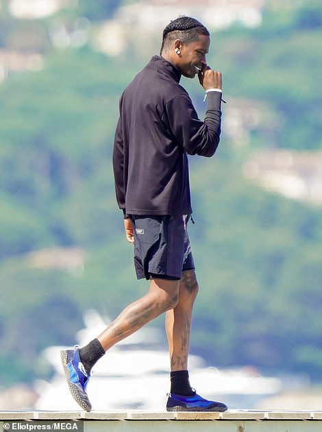 He also sported blue water shoes and was seen smiling widely as he talked on the phone at one point while walking on the dock