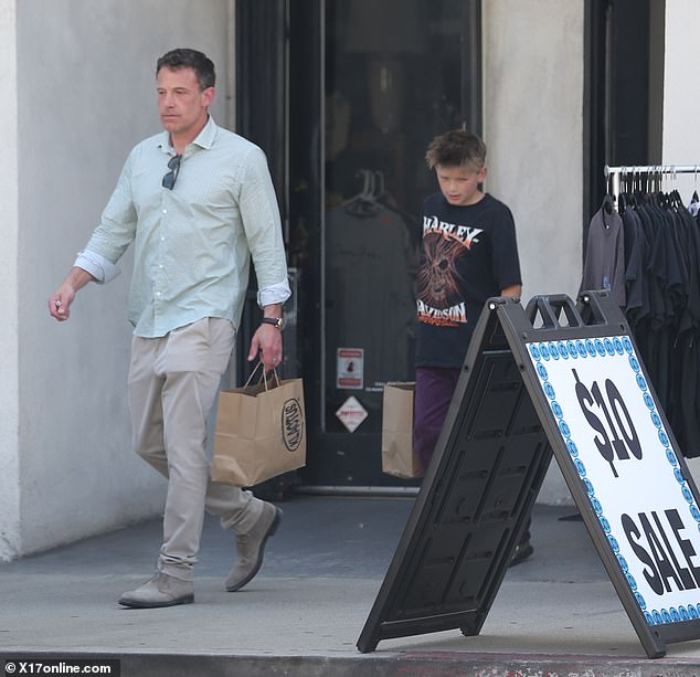 After sorting out the items from the rack, the father and son were seen walking out of the store with shopping bags in their hands.