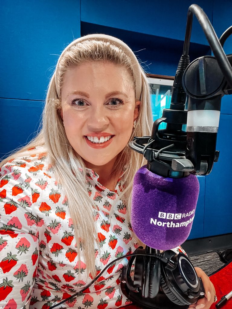 woman in strawberry print dress recording a radio show