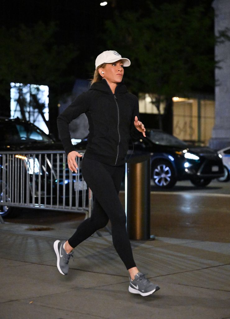 Jennifer Aniston jogging in black leggings and white hat