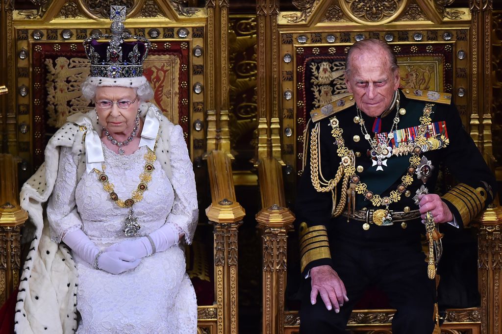The Queen and Prince Philip sit on the golden throne
