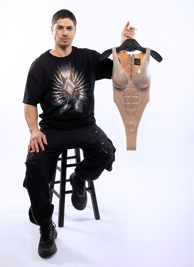 Asher Levine poses with a bodysuit he created for Doja Cat's Coachella performance