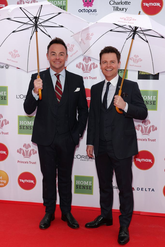 Ant and Dec in suits holding umbrellas