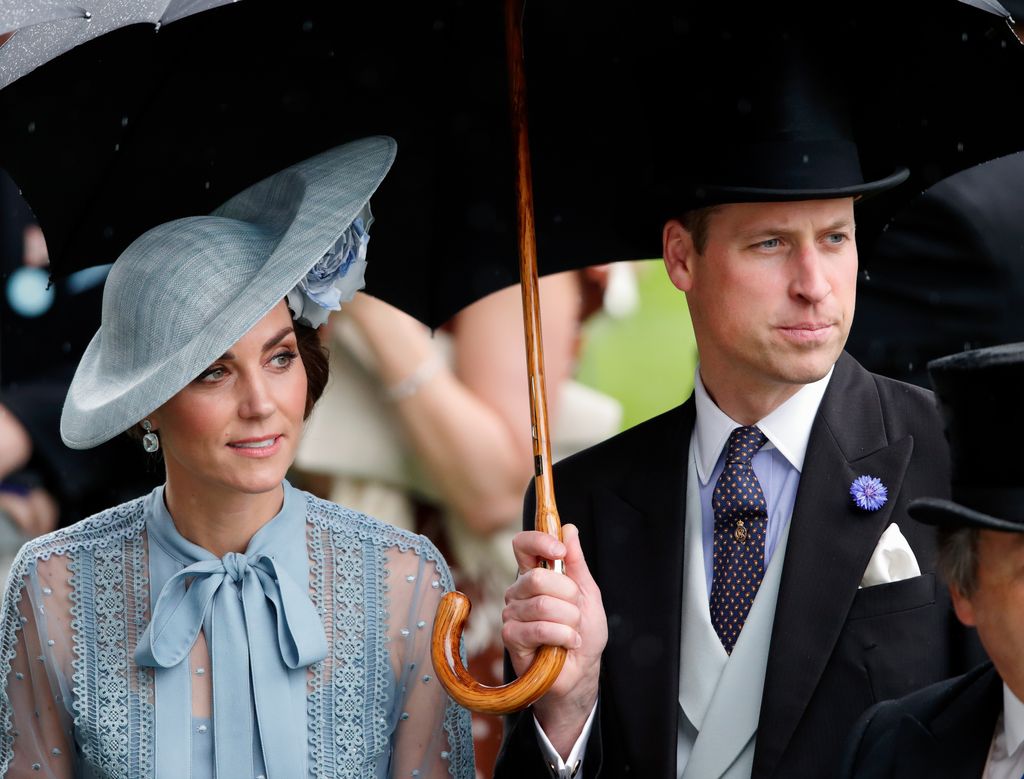 Princess Kate and Prince William shelter under an umbrella while attending the opening day of Royal Ascot at Ascot Racecourse on June 18, 2019 in Ascot, England.