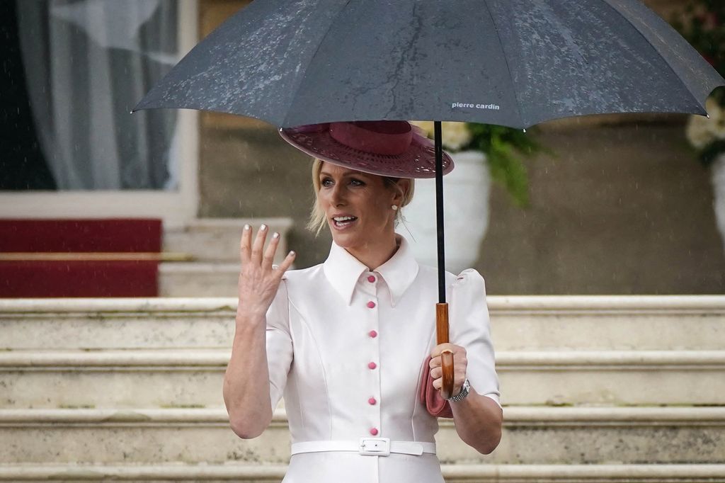 Zara Tindall in a white button down shirt dress with a pink hat at Buckingham Palace 