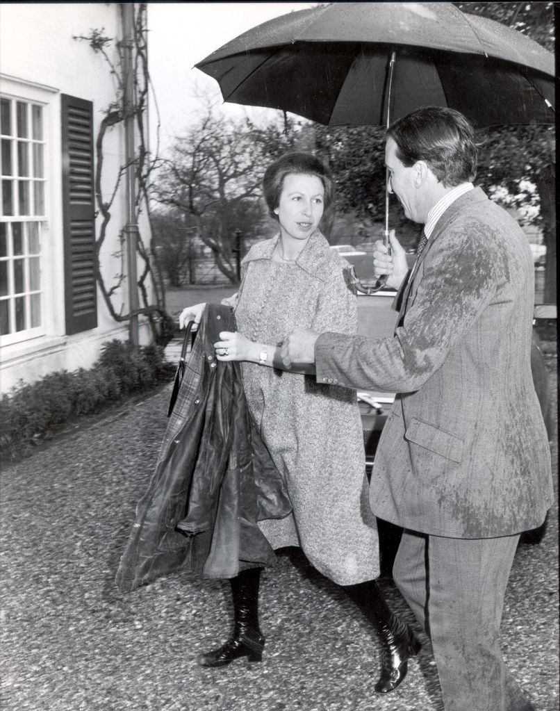 Princess Anne wearing knee-high boots under an umbrella