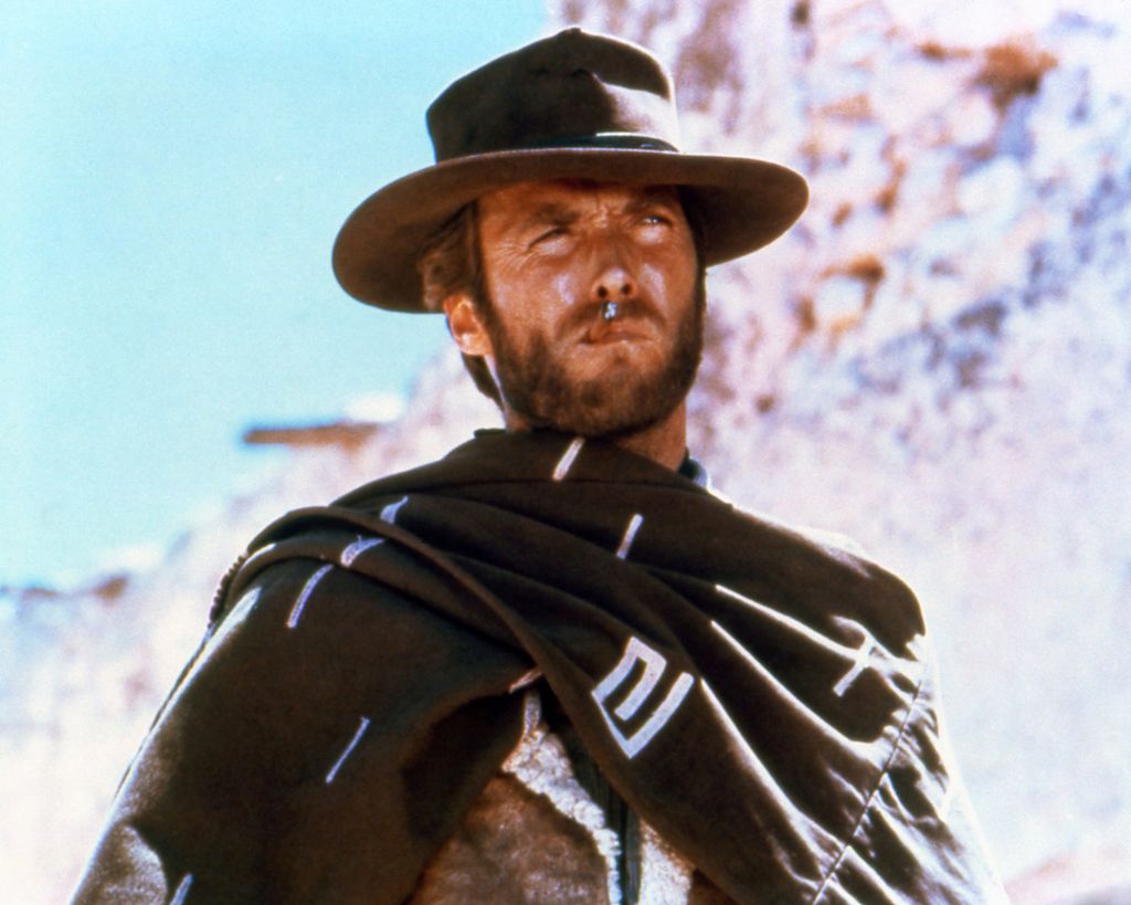 Clint Eastwood, American actor, smoking a cigar, wearing a brown hat and poncho in a promotional still released for the film 'A Fistful of Dollars,' Spain, 1964. Eastwood played 'The Man with No Name' in this spaghetti western directed by Sergio Leone (1929-1989). (Photo by Silver Screen Collection/Getty Images)