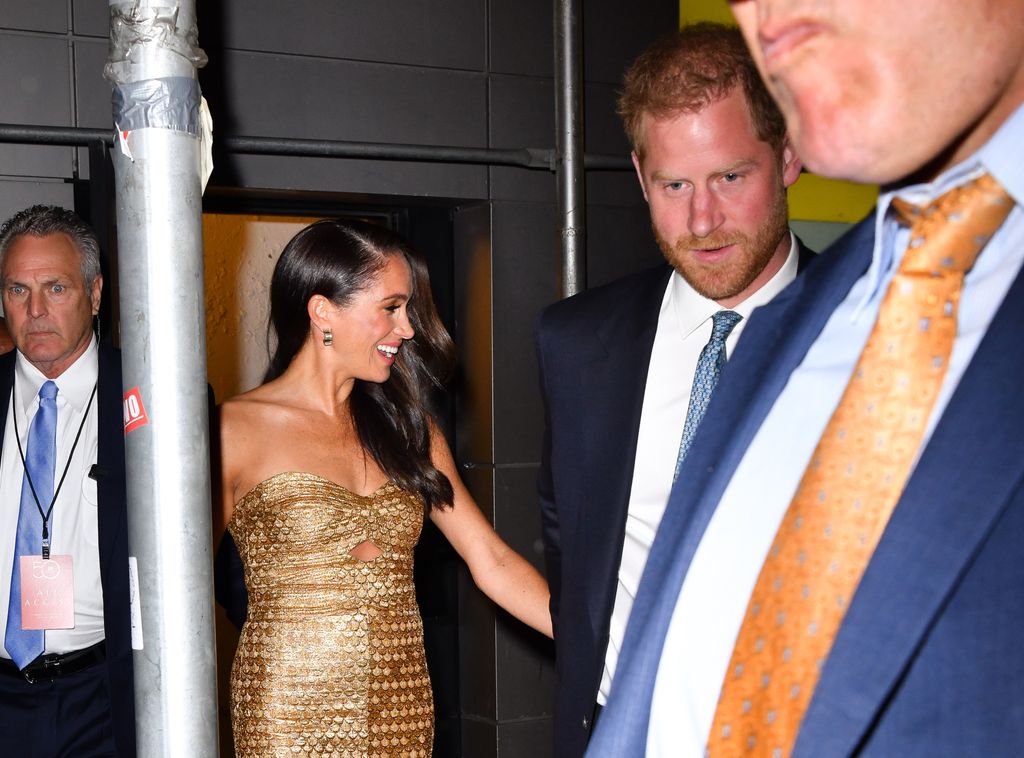 Prince Harry walking with Meghan Markle and security