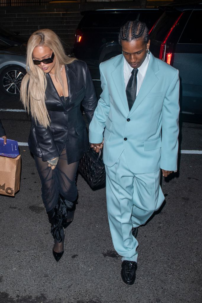 Rihanna walking in a black dress and ASAP Rocky walking in a blue suit 