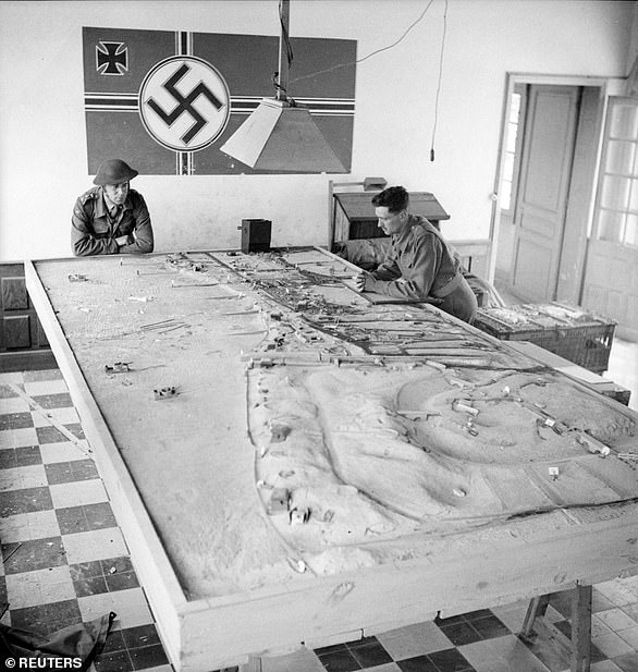 Canadian soldiers study a German plan of the beach during D-Day landing operations in Normandy. Once the beachhead had been secured, Omaha became the location of one of the two Mulberry harbors, prefabricated artificial harbors towed in pieces across the English Channel and assembled just off shore