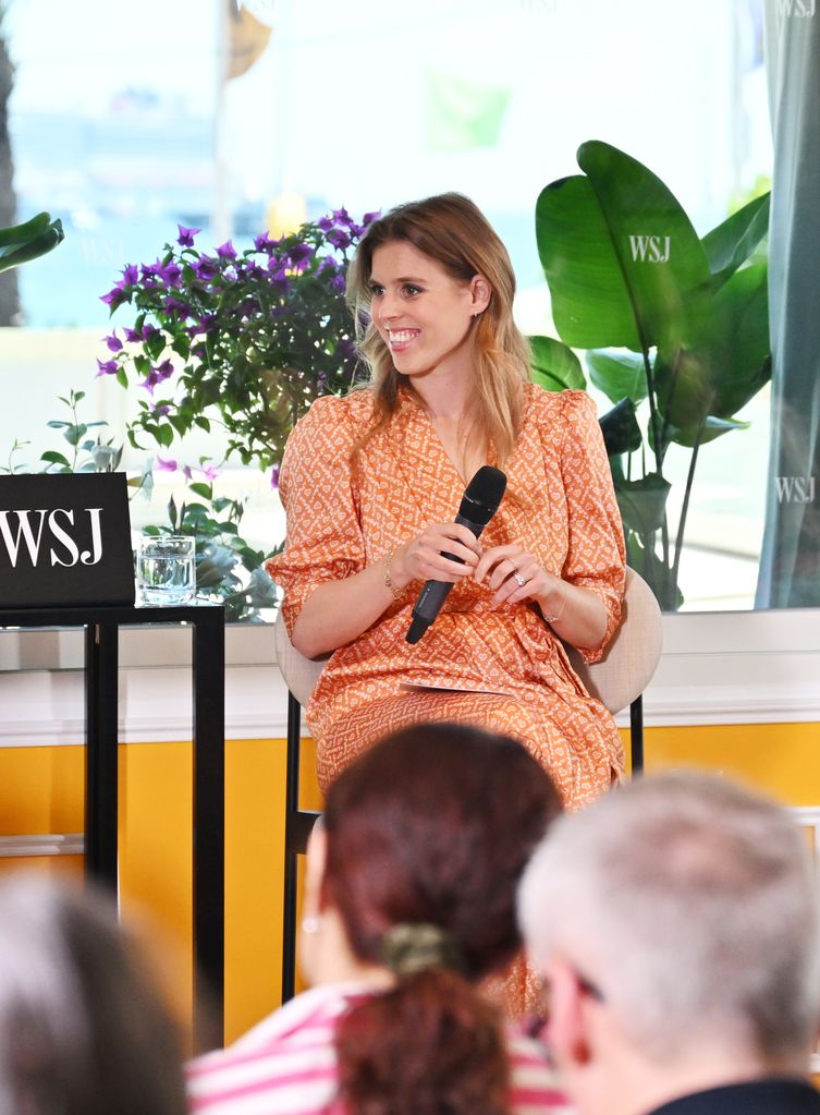 Princess Beatrice smiling and holding a microphone