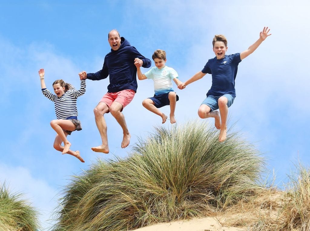Prince William jumping on a Norfolk beach with George, Charlotte and Louis