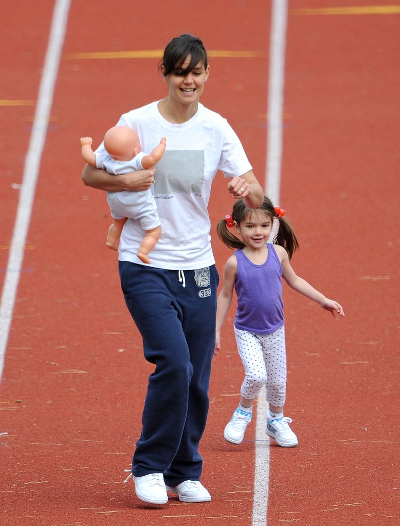 Katie Holmes and her daughter Suri Cruise run on a track field on October 12, 2009 in Boston, Massachusetts.