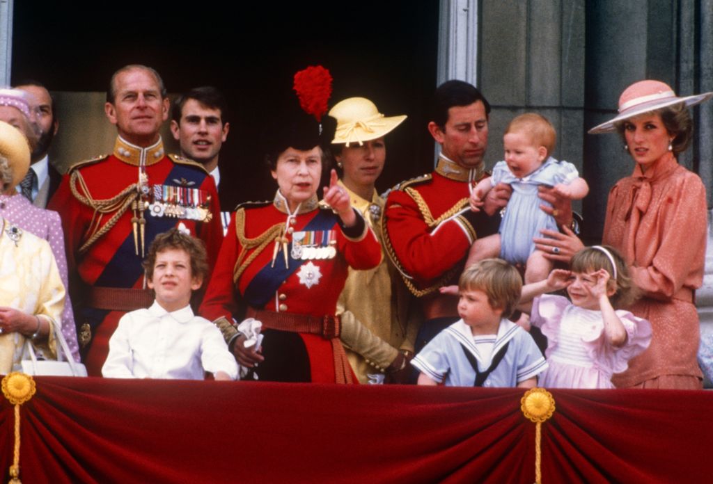 Prince Charles holds Prince Harry on his lap on the palace balcony