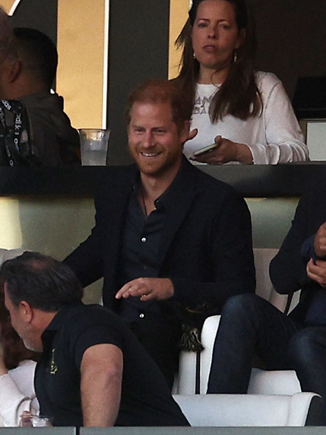 Prince Harry laughs while watching a football match