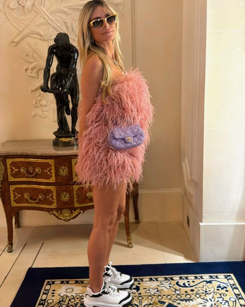 Heidi Klum poses in a feathered mini dress before spending the day in Paris