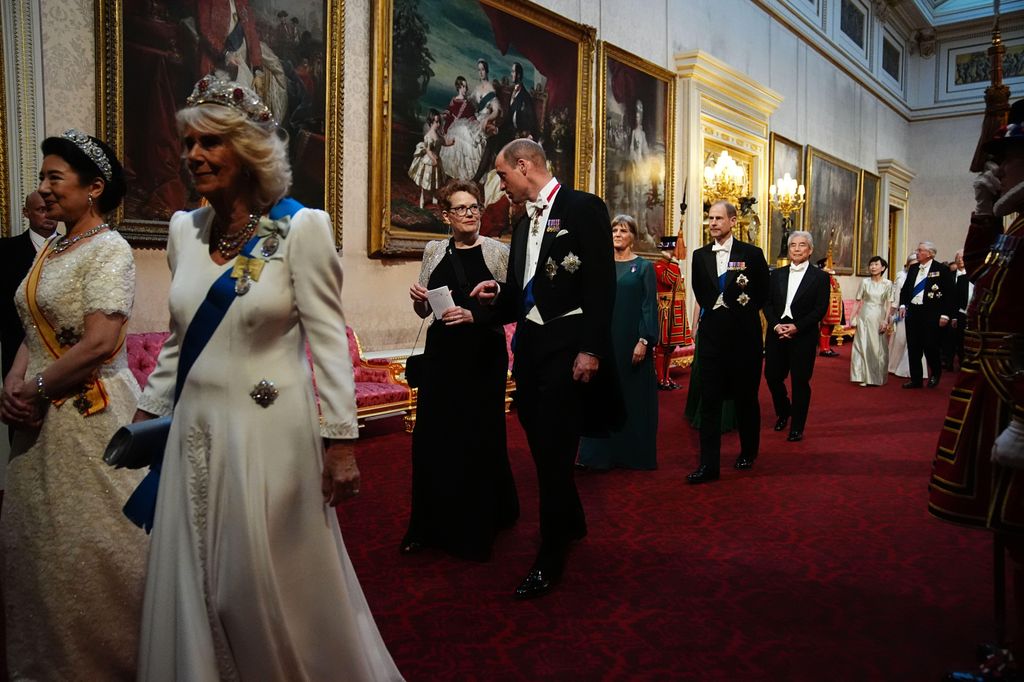Prince William and a woman walk behind Queen Camilla and Empress Masako