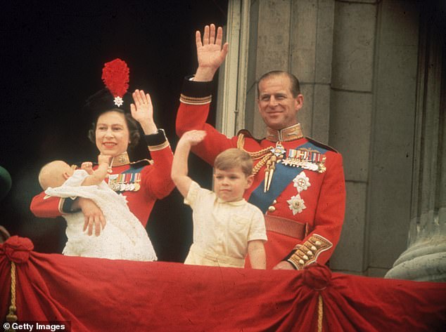 Queen Elizabeth, Prince Philip, Prince Andrew and a baby Prince Edward waving to the crowds from the balcony at Buckingham Palace