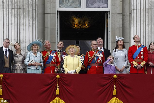 Queen Elizabeth II and Prince Philip watch a Royal Air Force flypast with their family from the balcony in 2012