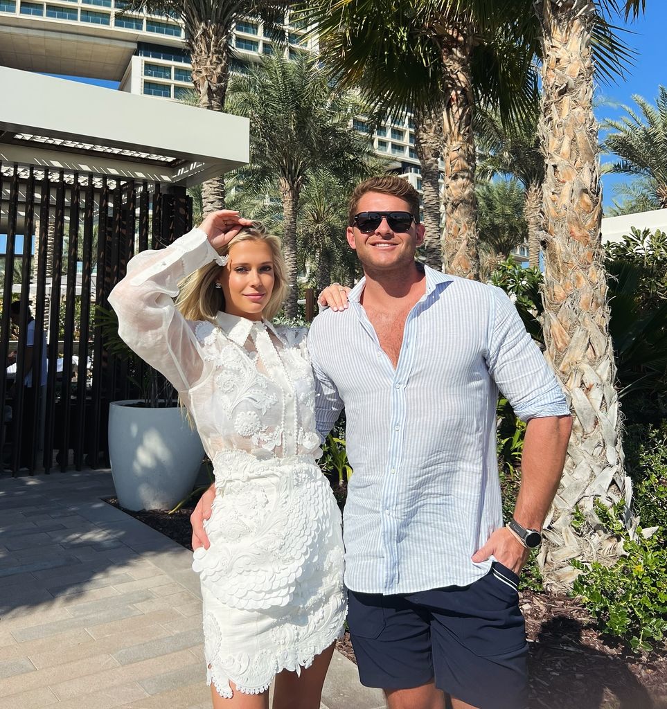 Amelia Spencer in a white dress with Greg Mallett on holiday