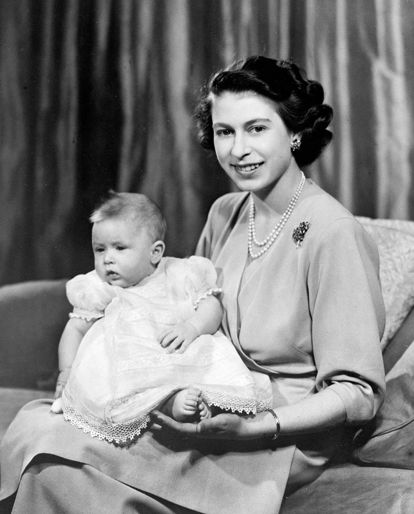 The Queen holds her newborn Prince Charles in her arms