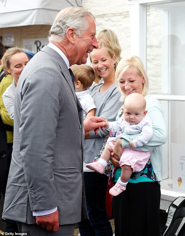 A baby held tightly on to the then Prince of Wales' finger during a walkabout as he visited Padstow during his annual summer tour of Cornwall in July 2015