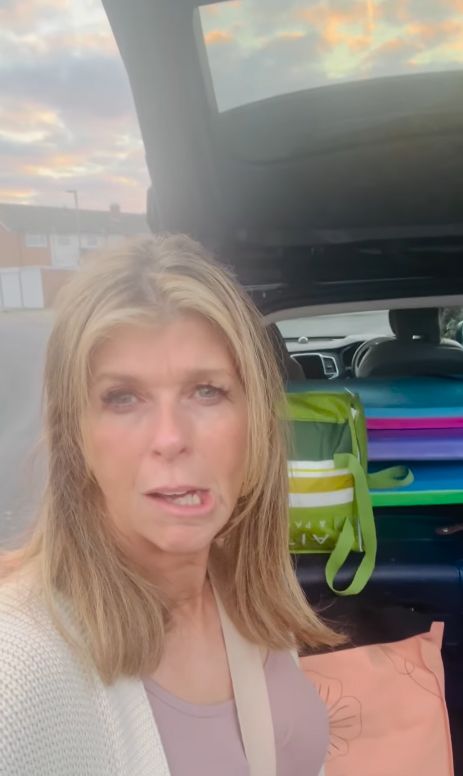 Kate Garraway stands in front of an open car