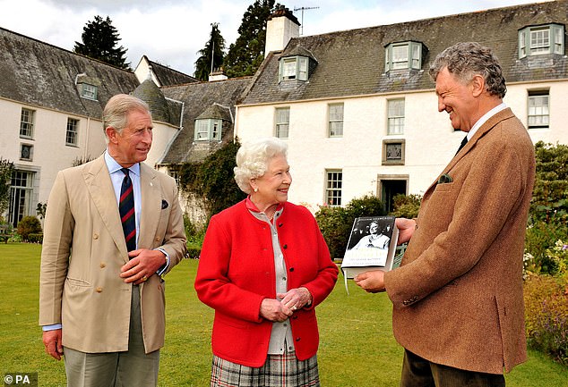 Queen Elizabeth and her son Charles, then Prince of Wales, can be seen presenting a copy of the Queen Mother's official biography by author William Shawcross in 2009.