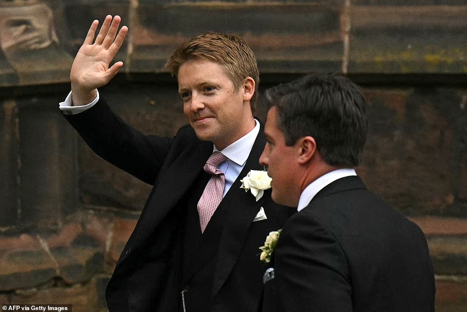 Hugh smiles and waves as he arrives at the cathedral in Cheshire to wed Olivia