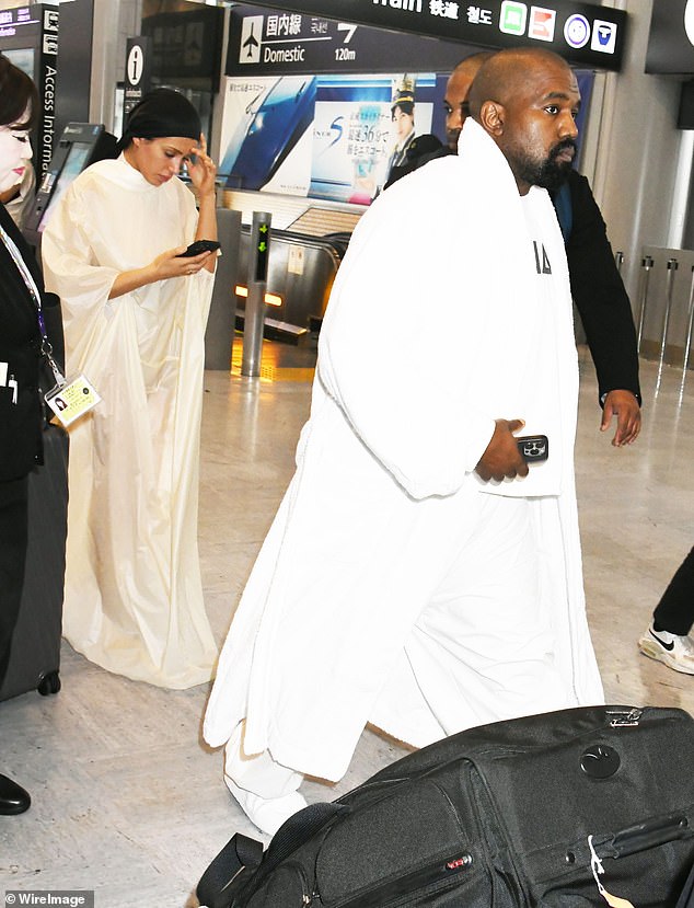 Sensei wore a more opaque version of his robe at the airport on June 9, while West wore the same shirt