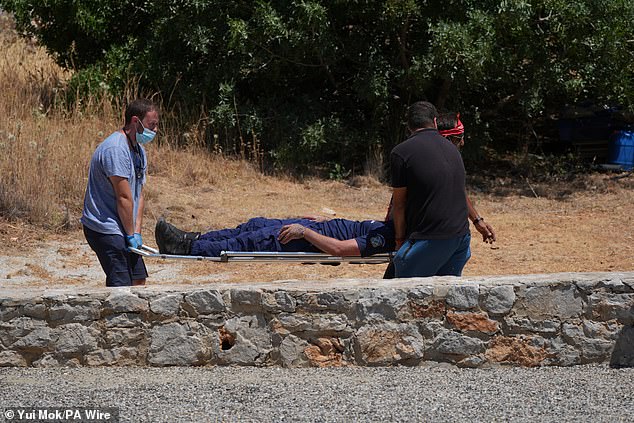 A member of the search team is stretchered away at Agia Marina in Symi, Greece