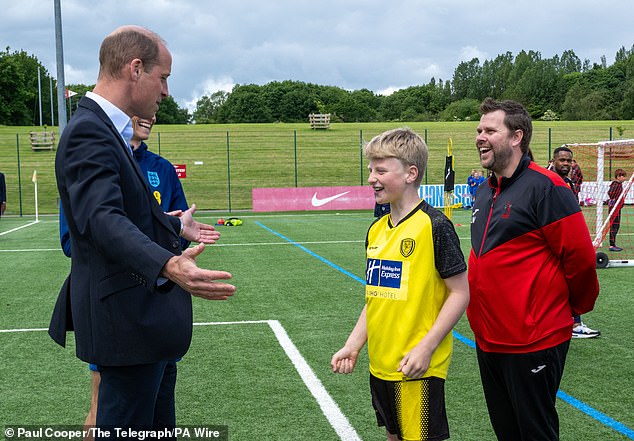 The Prince of Wales speaks to schoolchildren during a visit to St George's Park today