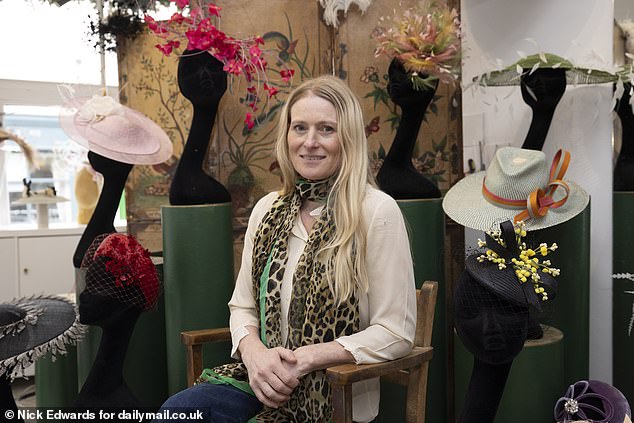 Milliner Jess Collett sits surrounded by her eye-catching hats in her Notting Hill studio