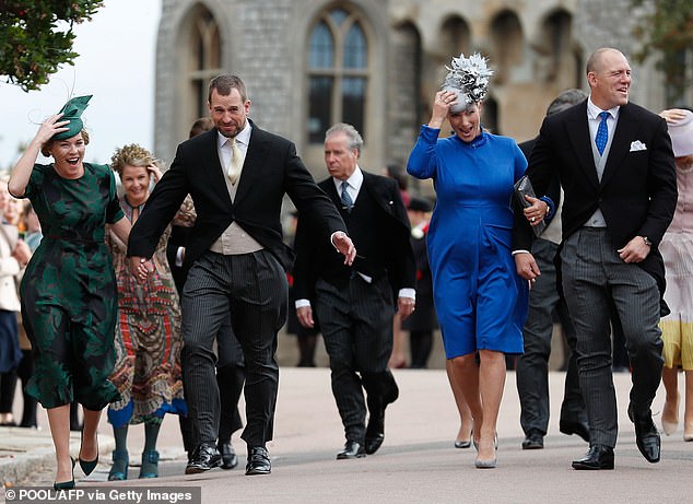 Peter Phillips (second from left), Autumn Phillips (second from left), Zara Tindall (second from right) and Mike Tindall (right) also braving the wind at Princess Eugenie and Jack Brooksbank's wedding