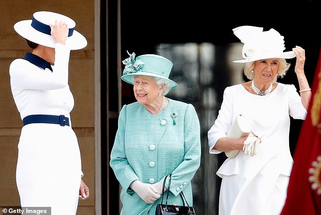 Melania Trump (left) and Camilla, Duchess of Cornwall, hold their hats during a formal welcome at Buckingham Palace Gardens for President Trump in 2019