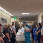 Sobbing hospital staff form guard of honor for beloved children’s nurse, 58, as she is taken off life support after stroke and wheeled away for organ donation surgery