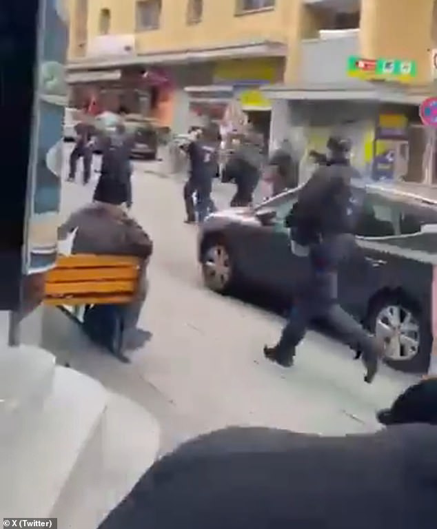 Riot police opened fire on an axe-wielding man after he allegedly threatened police officers.