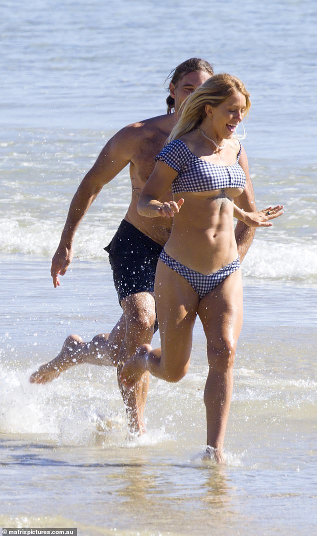 Showing off her toned abs, Ali's bikini top barely clung to her chest as she ran away from her delighted boyfriend